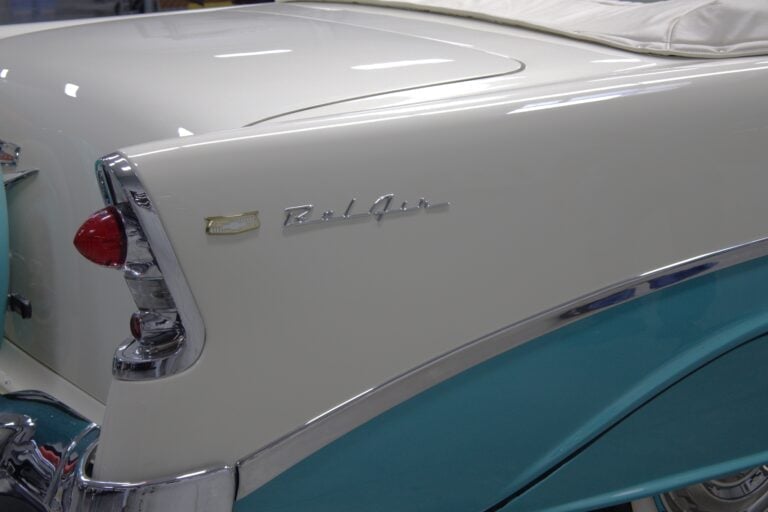 Close-up of vintage 1950s Ford car showing white upper body with turquoise lower panel and chrome trim details