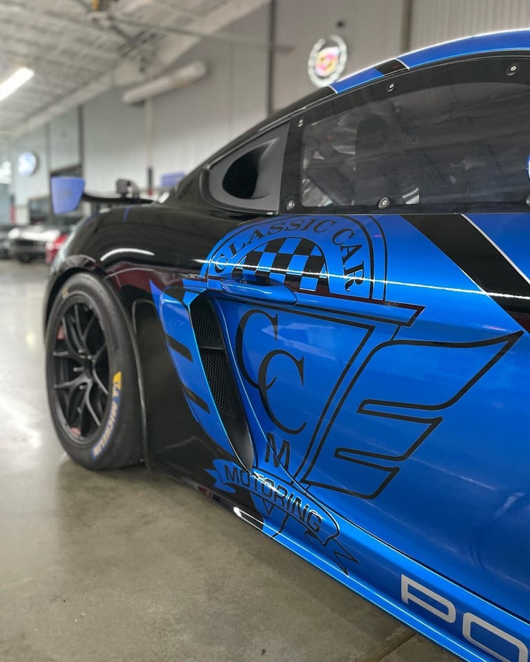 Blue and black sports car with geometric graphics parked in a garage workshop