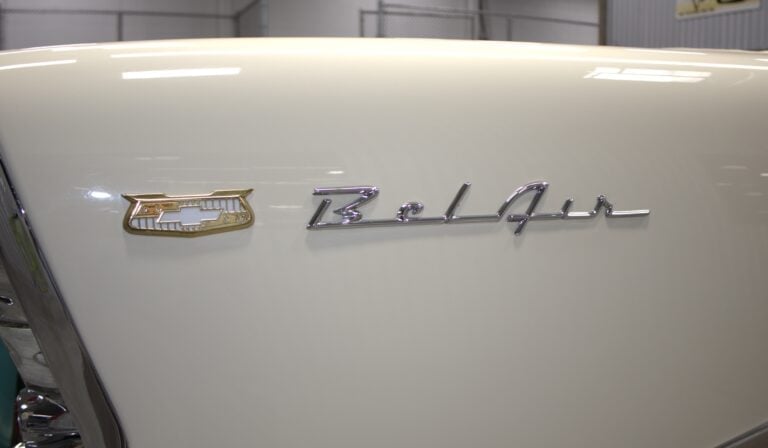 Close-up of a white Cadillac car hood showing the hood ornament and Cadillac badge emblem