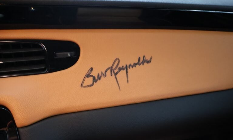 Orange car dashboard with signature embossed on leather panel and black trim