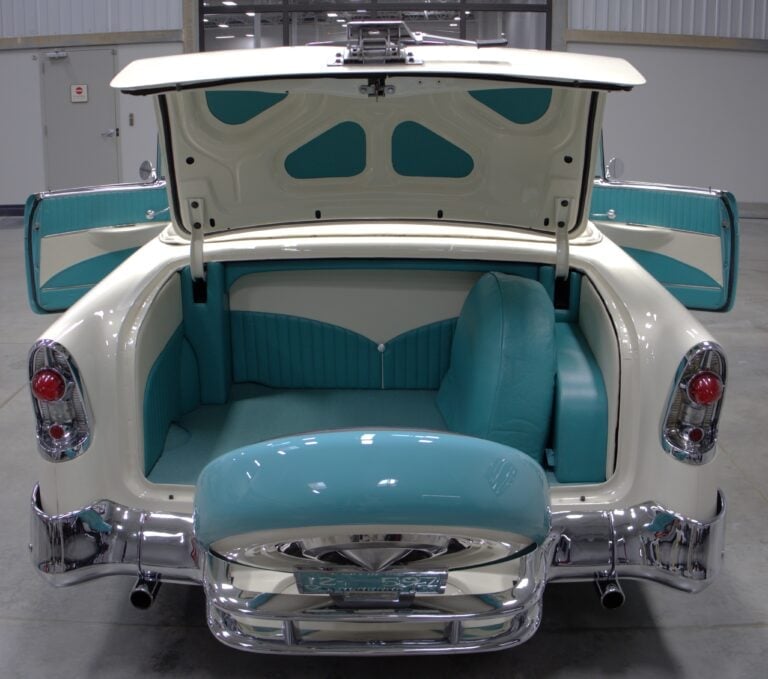 1957 Chevrolet Bel Air with open trunk and doors showing turquoise and white interior upholstery